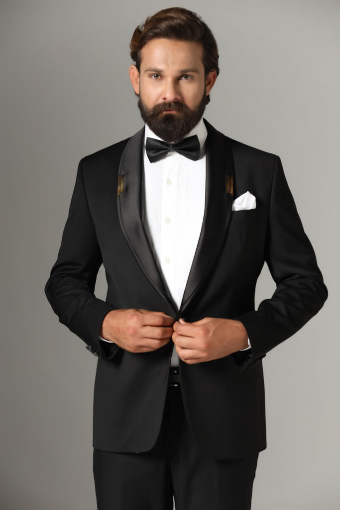 Make a statement in our Jet-Black Tuxedo. Shawl collar accentuated with a golden metal plate. Crafted from wool-rich fabric, paired with Jet-Black trousers.