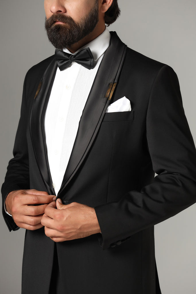 Make a statement in our Jet-Black Tuxedo. Shawl collar accentuated with a golden metal plate. Crafted from wool-rich fabric, paired with Jet-Black trousers.