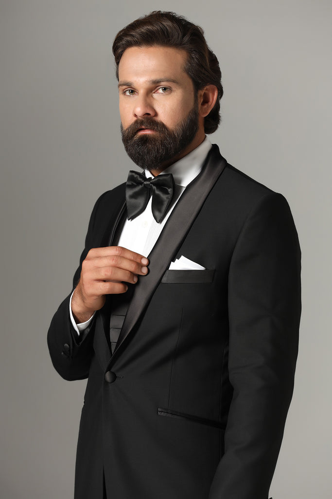 Elevate your formal look with our 3-Piece Black Tuxedo. Wool-rich fabric, shawl collar in black satin. Complete with jet-black waistcoat and trousers.