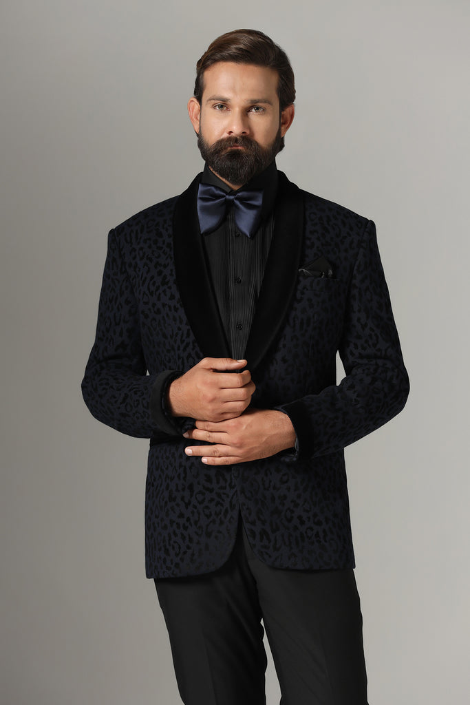 Distinguished elegance in our Textured Navy Blue Tuxedo. Black velvet shawl collar accents the coat, paired with jet black trousers.