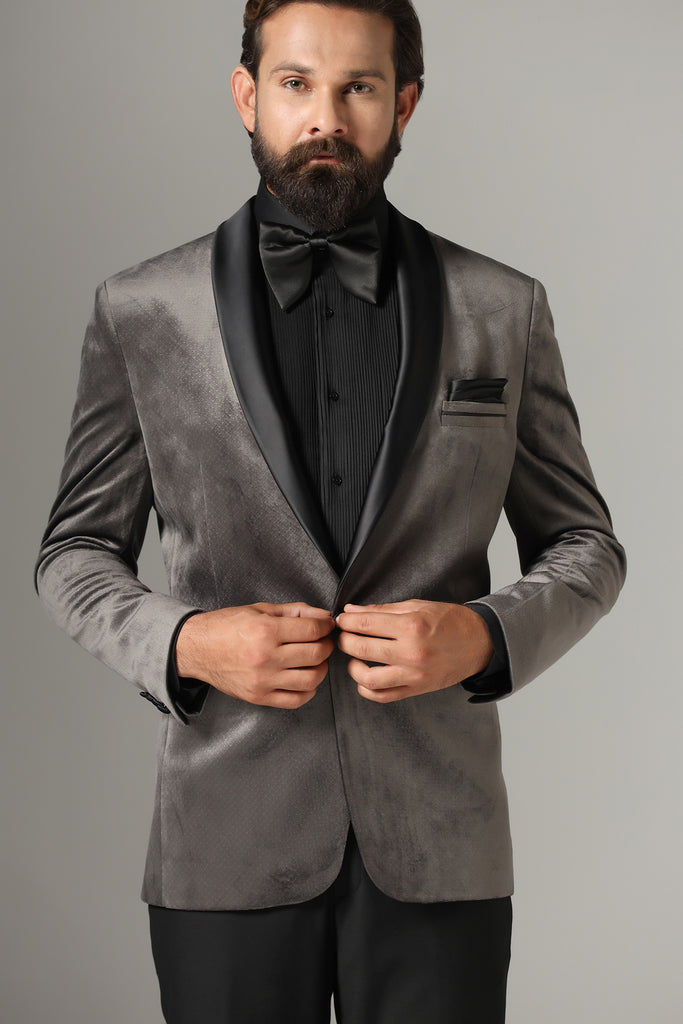 Distinguished elegance in our Grey Velvet Tuxedo. Black satin shawl collar accents the coat, paired with jet-black trousers for a refined look