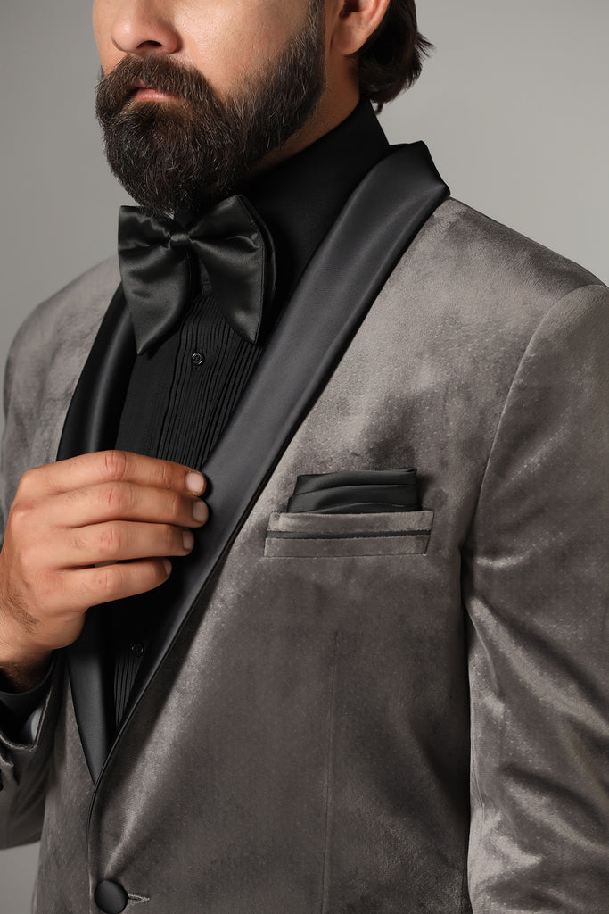 Distinguished elegance in our Grey Velvet Tuxedo. Black satin shawl collar accents the coat, paired with jet-black trousers for a refined look.
