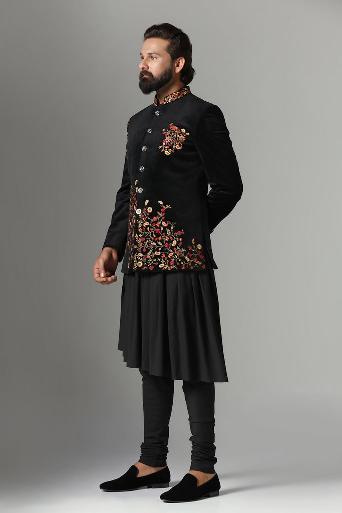 Elevate your style with our black velvet Bandhgala, adorned with colorful embroidery. Complete with a pleated black kurta and pajama set. Accessories sold separately.
