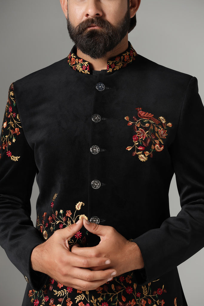 Elevate your style with our black velvet Bandhgala, adorned with colorful embroidery. Complete with a pleated black kurta and pajama set. Accessories sold separately.