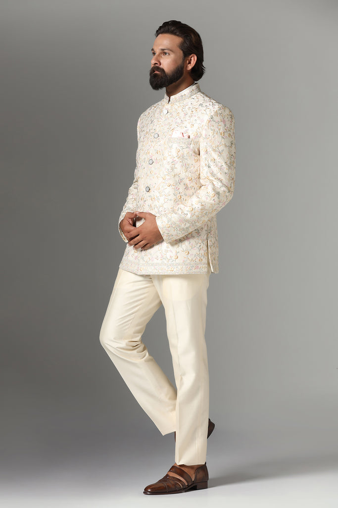 Exude sophistication in our off-white Bandhgala suit crafted from wool-rich fabric. Tonal embroidery adorns the garment, paired with matching off-white churidar trousers for a timeless look.