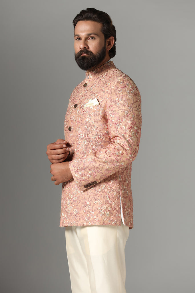 Dress in sophistication with our light orange Bandhgala suit, adorned with intricate embroidery. Complete with matching off-white trousers for a polished ensemble.