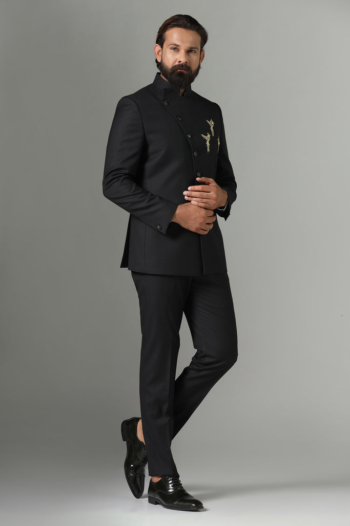 Elevate your occasion with our Asymmetric Black Bandhgala suit. Crafted from luxurious wool-rich fabric, it features intricate bird motif embroidery for a touch of sophistication. Paired with tapered trousers for a sleek finish.
