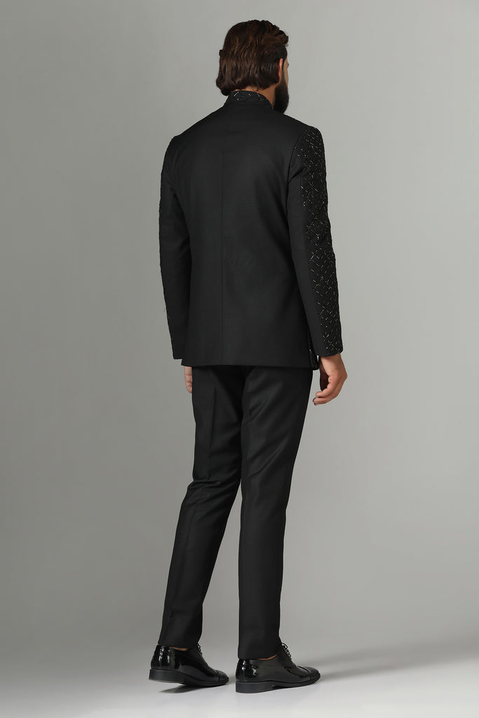 Dress with sophistication in our Black Bandhgala suit, tailored from wool-rich fabric and delicately embroidered in a geometric pattern. Paired with Polo trousers for a refined look.