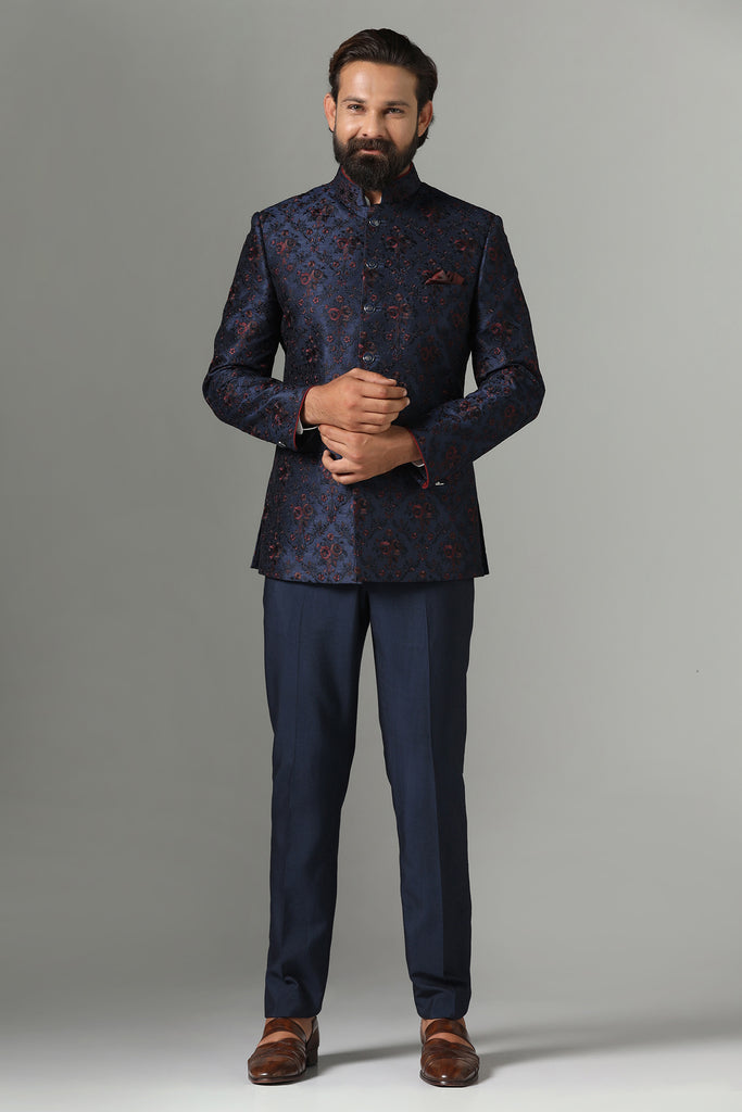 Exude elegance in our Navy Blue Bandhgala suit crafted from Raw-Silk fabric, adorned with floral embroidery. Paired with monochrome navy blue trousers for a sophisticated look.