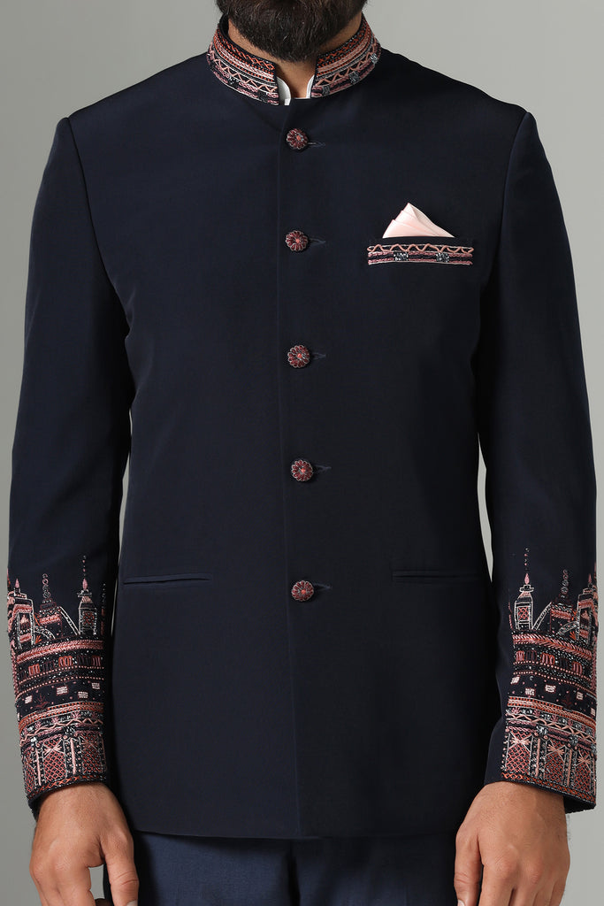 Elevate your style with our Dark Blue Bandhgala suit, featuring contrast embroidery on sleeves, collar, and pocket bone. Paired with navy blue trousers for a refined ensemble.