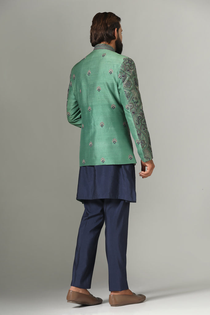 Adorned with intricate embroidery, our green Bandhgala suit exudes elegance. Paired with navy blue kurta and pajamas for a refined ensemble.
