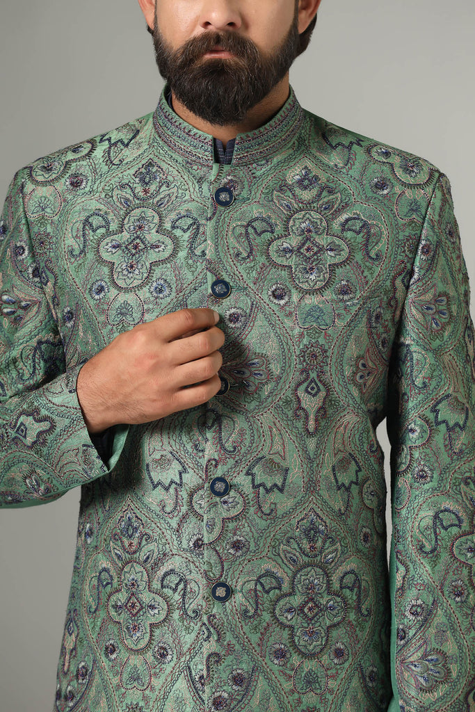 Adorned with intricate embroidery, our green Bandhgala suit exudes elegance. Paired with navy blue kurta and pajamas for a refined ensemble.
