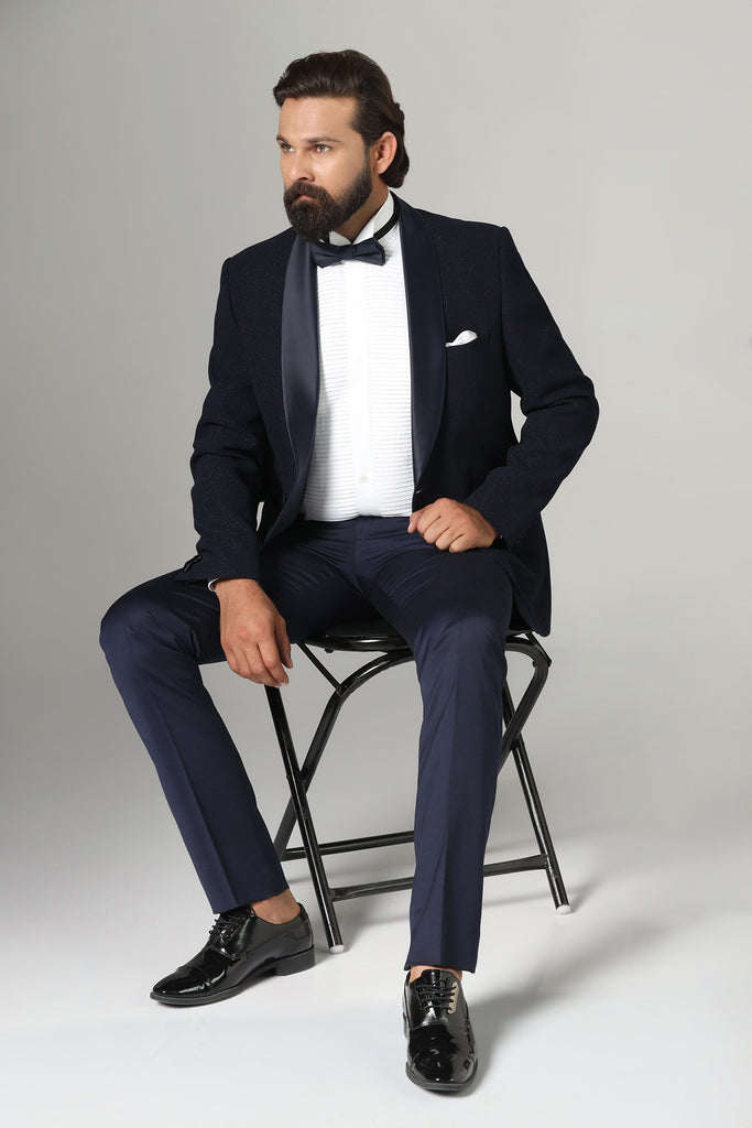 Distinguished elegance in our Dark Blue Textured Tuxedo. Classic shawl lapel, single button closure. Crafted from luxurious wool-rich fabric.
