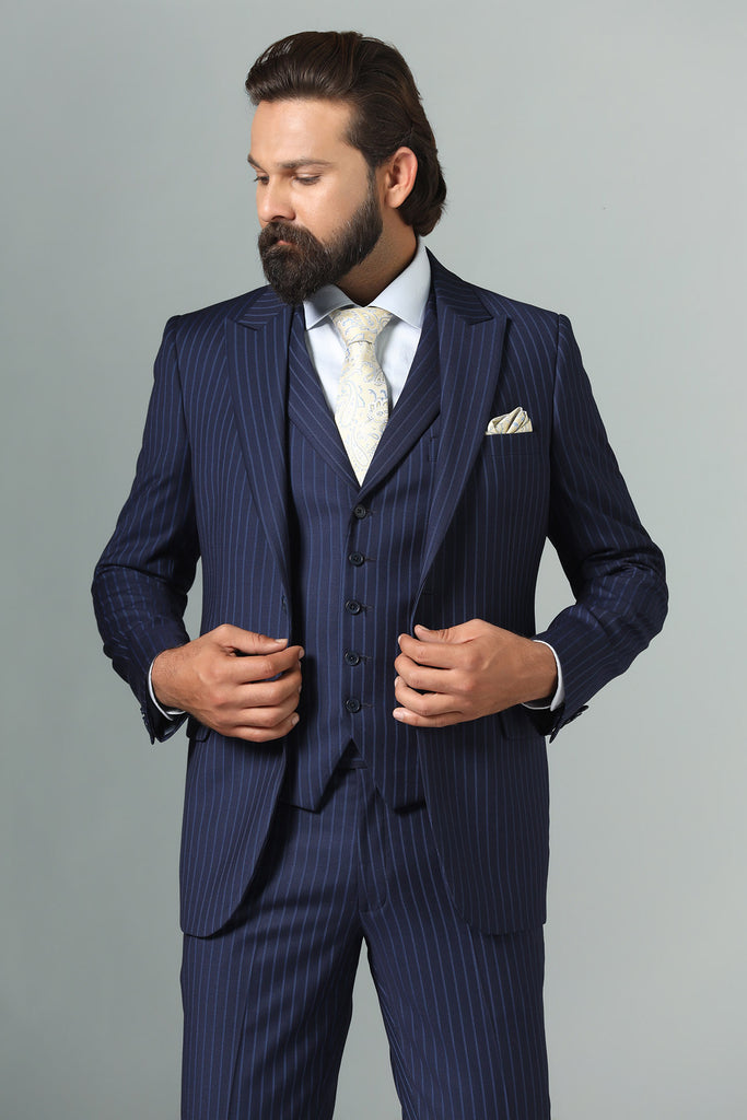 Distinguish your look with our Navy Blue Pinstripe Suit. Crafted from Navy Blue Terry-Rayon Fabric, featuring a peak lapel and a 5-button waistcoat.