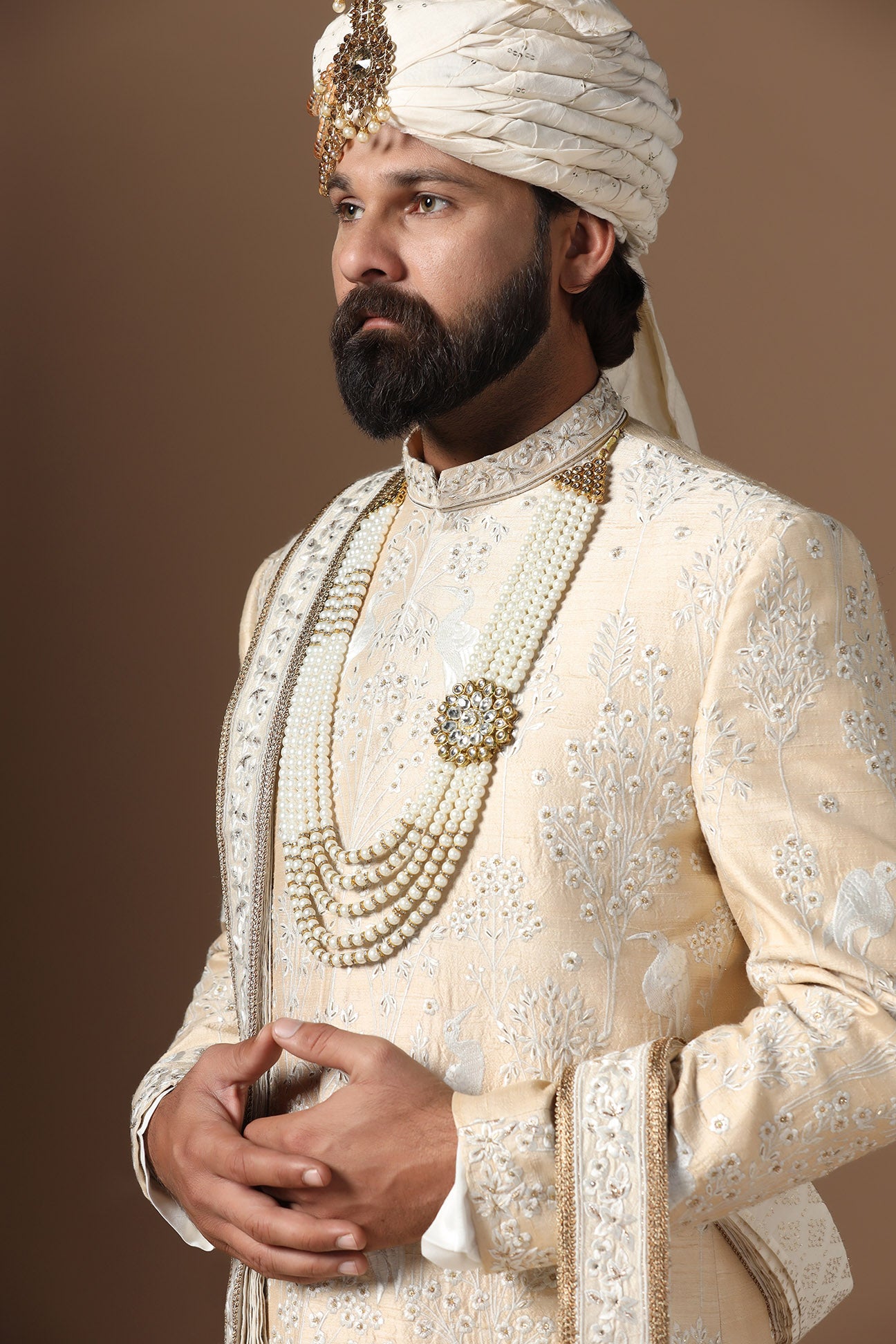Elevate your style with our beige sherwani with intricate floral and bird embroidery. Shop Now!