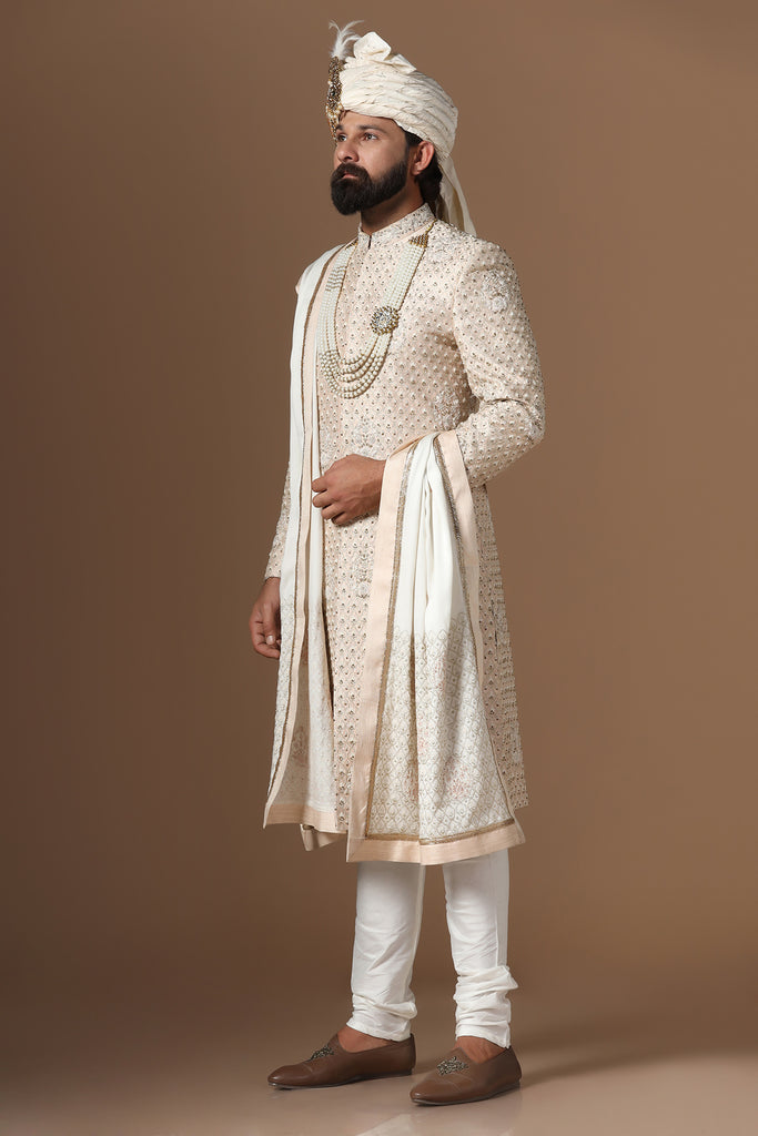 Elegance meets tradition in this light peach sherwani, adorned with subtle tonal embroidery. Complete with a kurta and pajama set for timeless style.