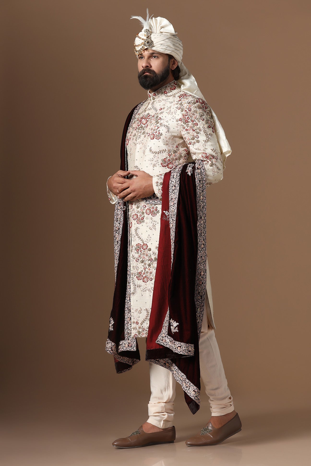 This beige sherwani is highlighted with floral embroidery patterns. Shop Now!