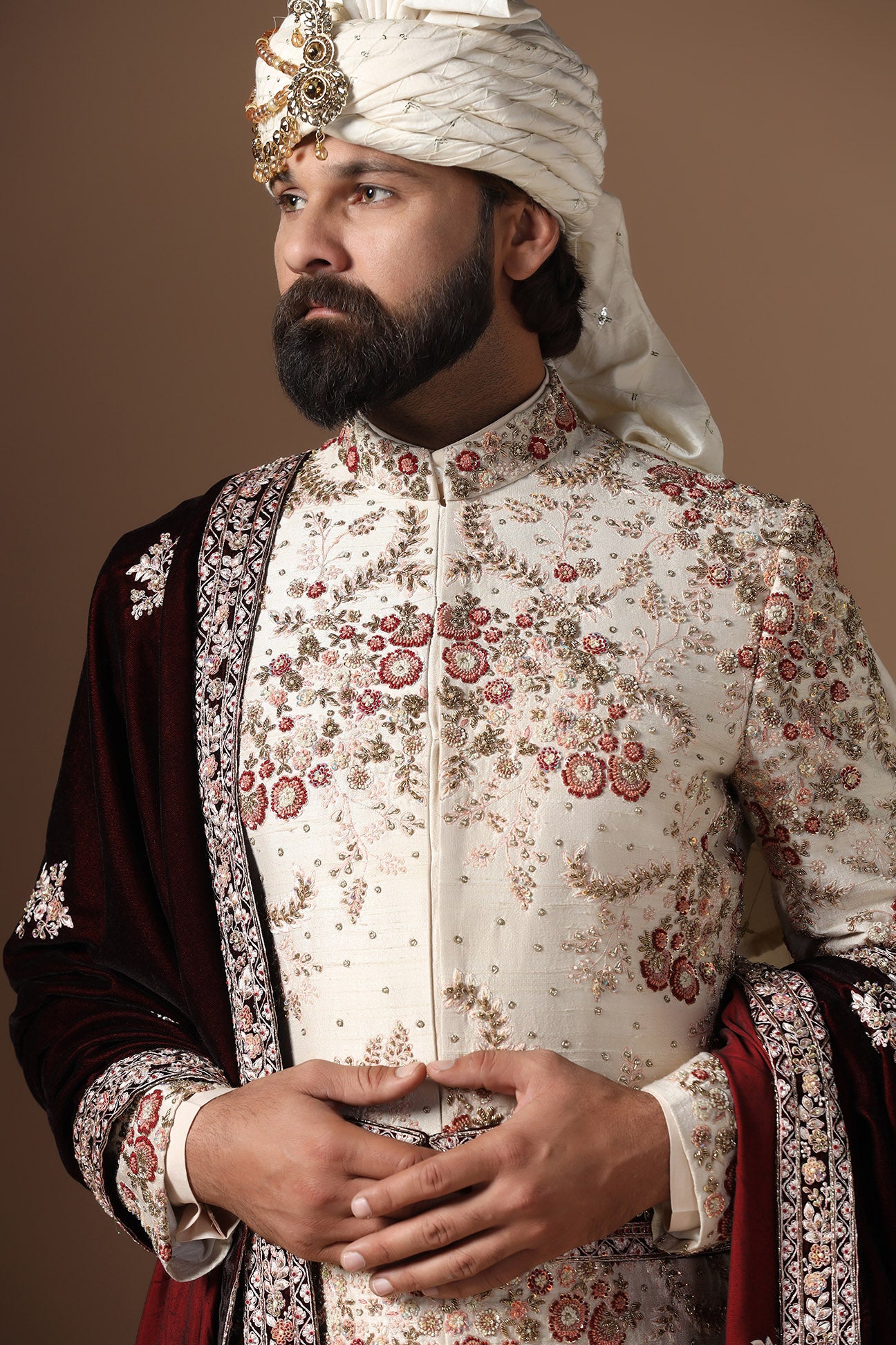 This beige sherwani is highlighted with floral embroidery patterns. Shop Now!