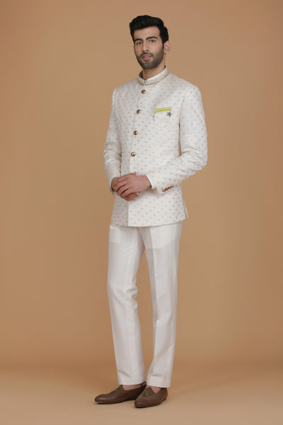 Indulge in luxury with our Tanchoi jacquard silk Bandhgala from Banaras, accentuated by dull gold buttons. Paired with off-white trousers for timeless elegance.