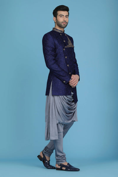 Drape yourself in elegance with our embroidered monga silk Bandhgala. Golden embroidery and buttons contrast the Navy outfit, complete with draped kurta and pajama set.
