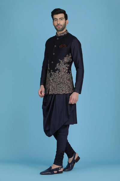 Exude regal charm in our Nehru jacket, adorned with intricate golden zari embroidery. Paired with a draped kurta and pajama set. Ships in 6-8 days.