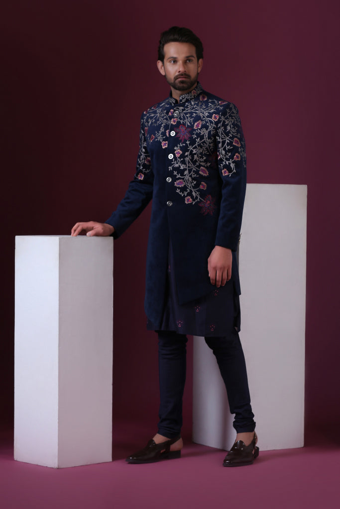 This navy blue velvet Indo-Western is highlighted by vibrant floral embroidery. Shop Now!