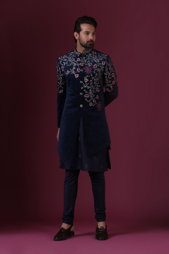 This navy blue velvet Indo-Western is highlighted by vibrant floral embroidery. Shop Now!