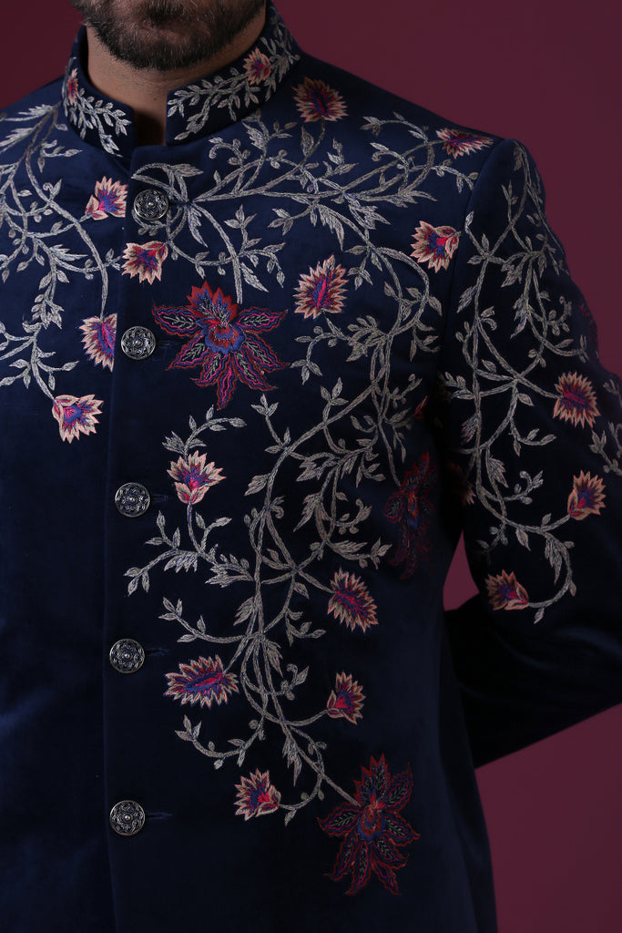This navy blue velvet Indo-Western is highlighted by vibrant floral embroidery. Shop Now!