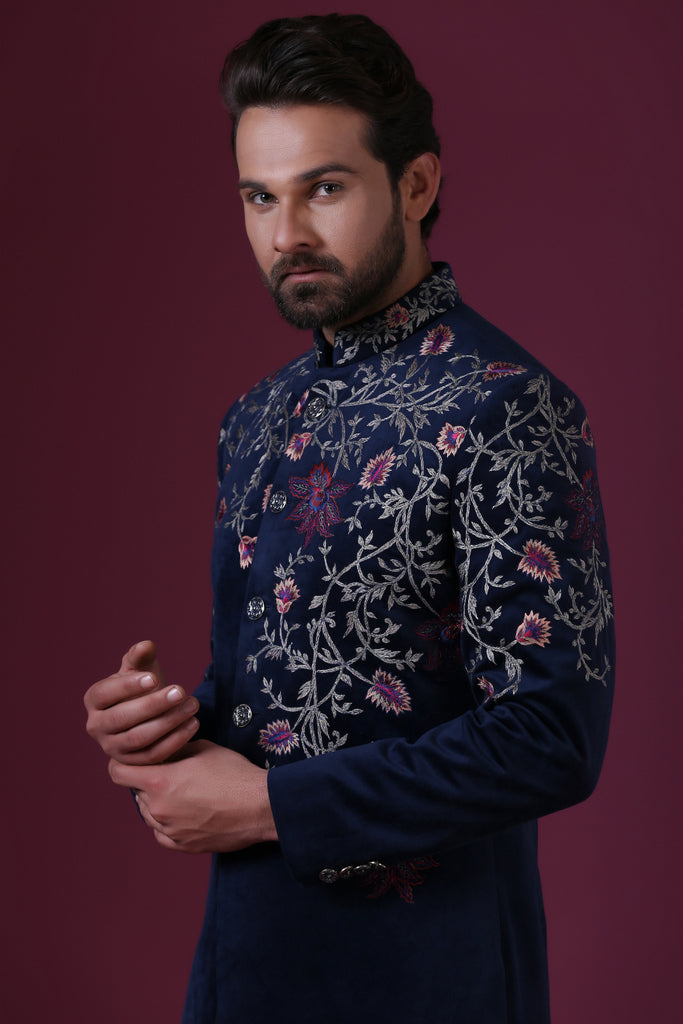 This navy blue velvet Indo-Western is highlighted by vibrant floral embroidery. Shop Now!