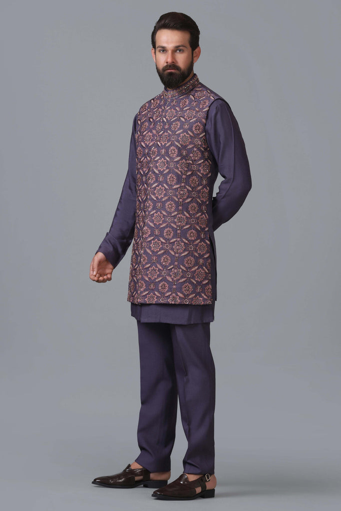 Elevate your ensemble with our long purple raw silk Nehru jacket, adorned with geometric embroidery. Pair it seamlessly with a coordinated purple kurta pajama set.