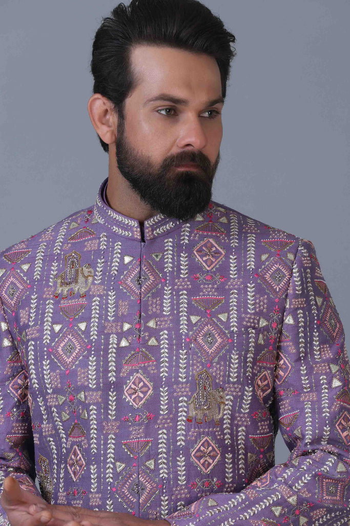 Make a statement in our lilac raw silk short Indowestern, adorned with vibrant geometric embroidery. Paired with a matching kurta and white pajamas for a striking ensemble.