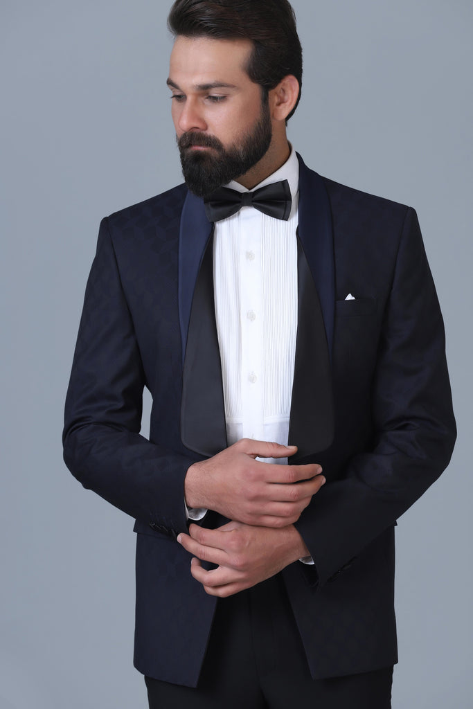 Elevate your style with our Designer Tuxedo in navy Jacquard wool-rich fabric. Layered shawl lapel adds sophistication. Paired with jet black trousers.