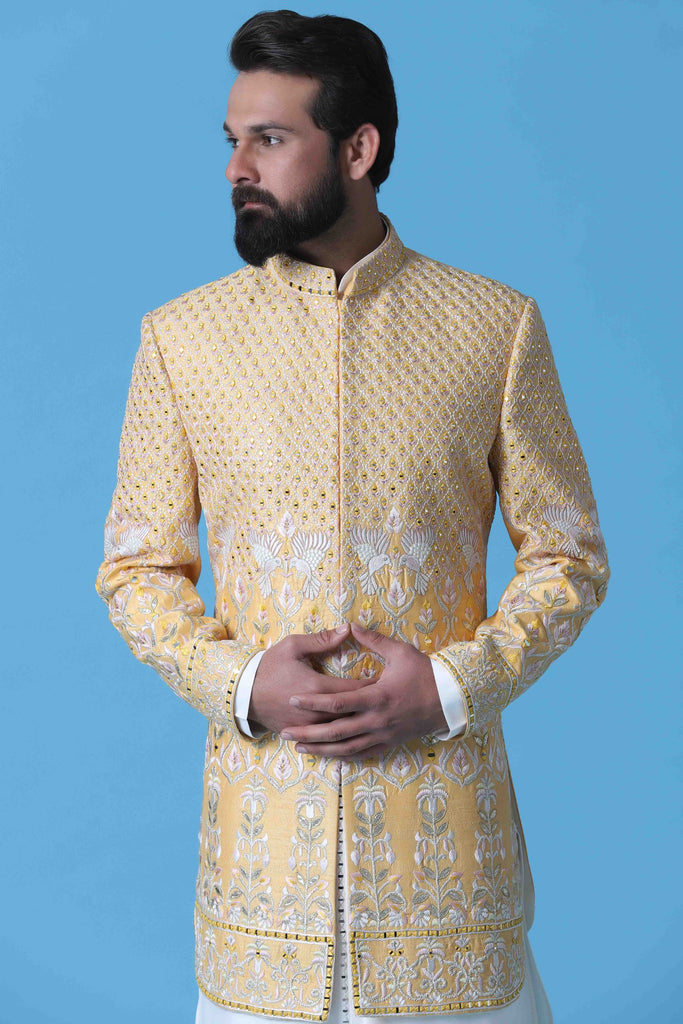 Exude elegance in this soft yellow Raw Silk Indowestern, adorned with intricate off-white dori embroidery. Paired with a matching kurta and silk trousers, it's the epitome of sophistication.