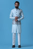 Elevate your style with our Light Blue raw silk Nehru Jacket adorned with floral embroidery and mirror work. Paired with a matching kurta and off-white trousers for timeless elegance.