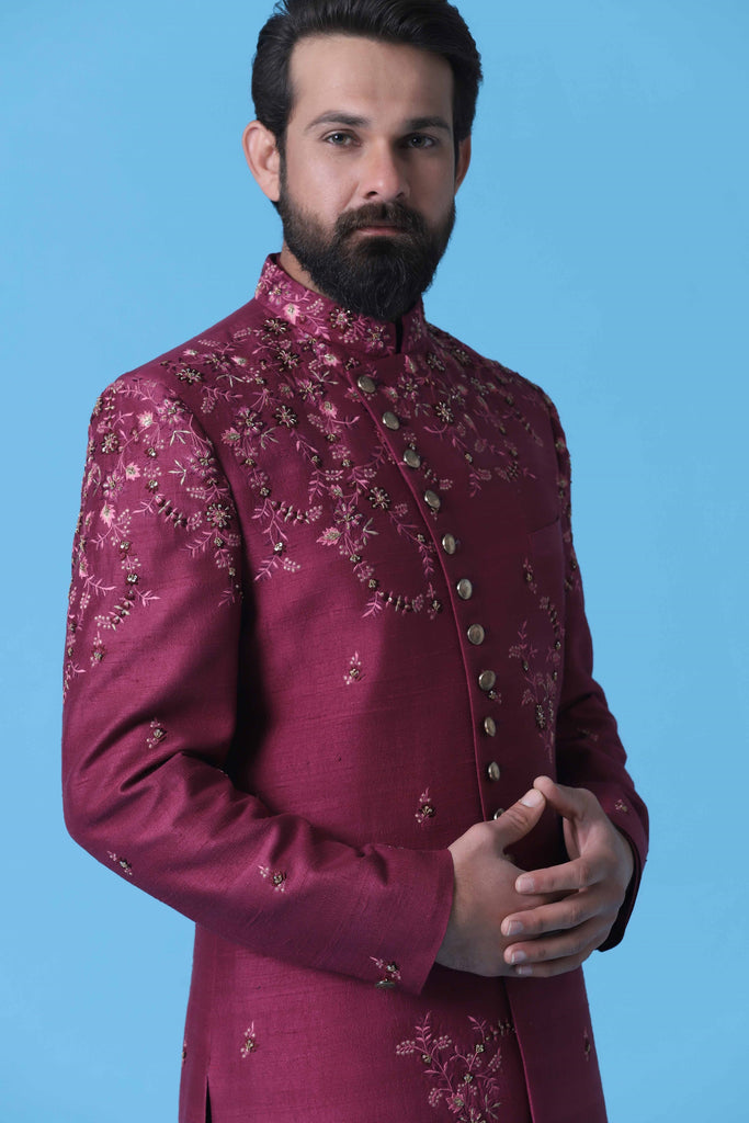 Enhance your ensemble with this maroon Indowestern, crafted from fine Raw Silk fabric. Featuring intricate floral embroidery along the front, it exudes elegance and sophistication.