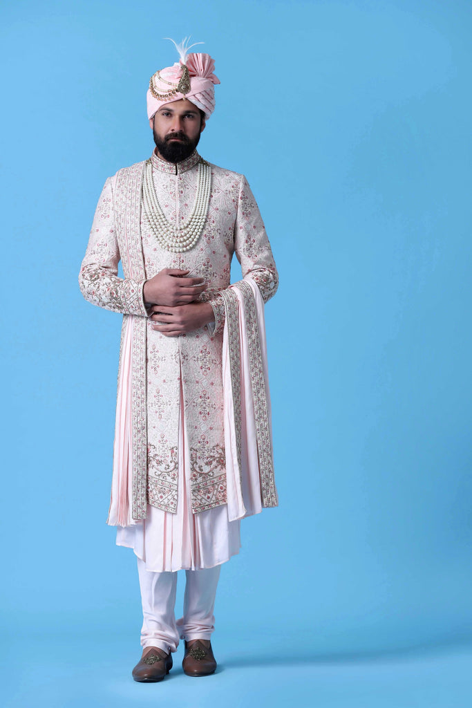 Elevate your style with this regal Sherwani crafted from fine raw silk fabric. Adorned with tonal embroidery on the front and embroidered motifs along the back for a distinguished look.