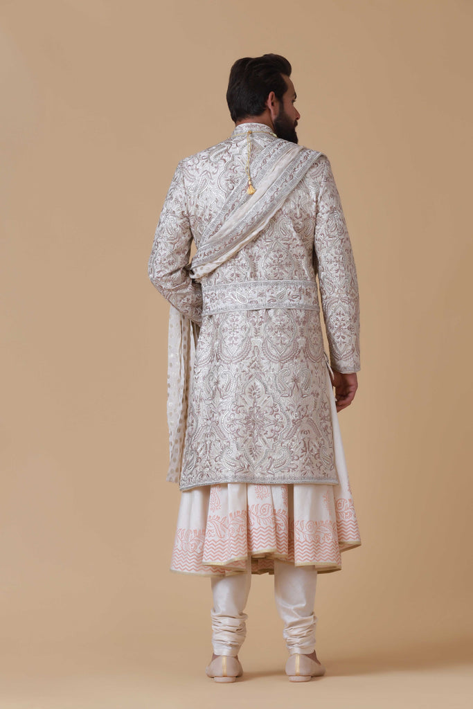 Charm in beige and pink hues with this elegant Sherwani, adorned with intricate embroidery for a touch of sophistication.