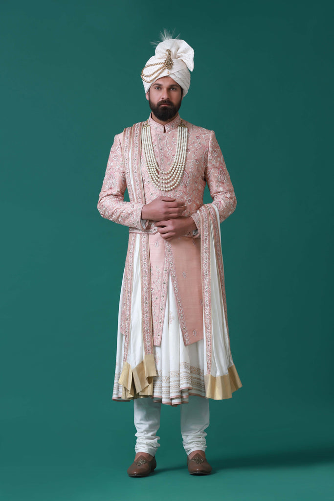 Elegant peach sherwani with tonal floral embroidery, paired with a pleated kurta and pajama set for a timeless ensemble.