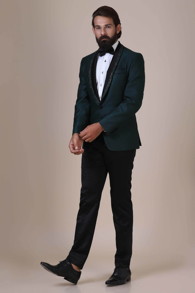 Step into elegance with our Green Tuxedo. Satin shawl collar adorned with subtle embroidery. Green textured fabric coat paired with Jet-Black trousers.