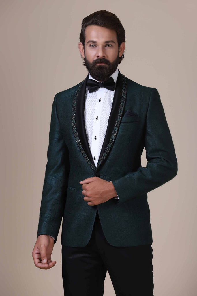 Step into elegance with our Green Tuxedo. Satin shawl collar adorned with subtle embroidery. Green textured fabric coat paired with Jet-Black trousers.