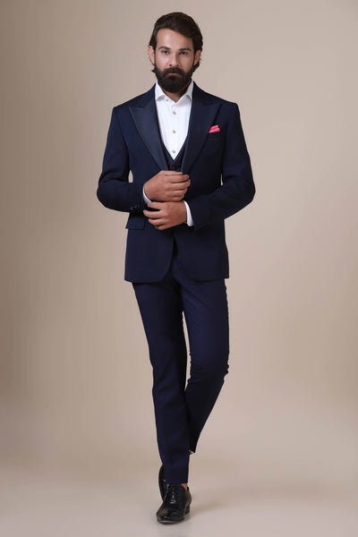Dress with refined elegance in our Navy tuxedo. Notched lapel, single button closure. Subtle paisley jacquard adds sophistication. Complete with plain Navy waistcoat and trousers.