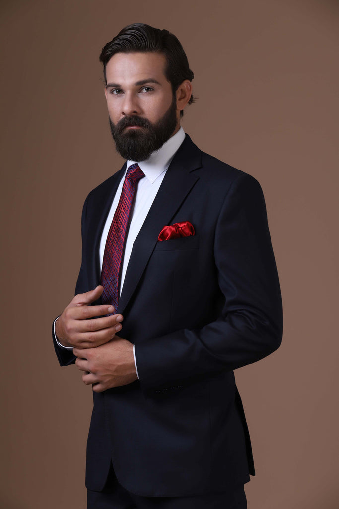 Elevate your style with our classic Navy Blue Suit. Crafted from luxurious wool-rich fabric, featuring a notched lapel and 2-button closure for timeless sophistication.