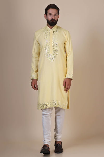 Elevate your style with our yellow embroidered Kurta Pajama, featuring subtle mirror work across the body, paired with fitted churidar trousers for a refined ensemble.