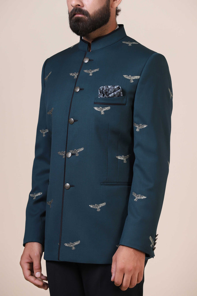 Elevate your style with our Teal Bandhgala suit, tailored from pure wool fabric. Adorned with eagle motif embroidery, paired with jet black trousers for a refined ensemble.
