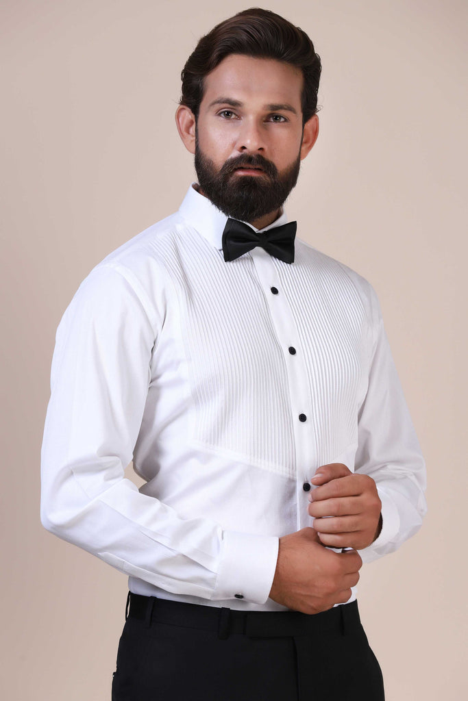 Tailored from premium cotton, this timeless white tuxedo shirt boasts vertical pintucks on the front, complemented by black buttons and a classic collar.