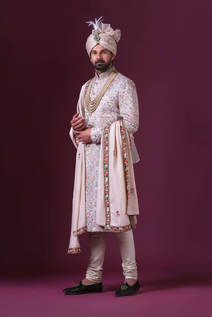Charm in white with multicolor floral embroidery, exuding soft pastel elegance in this exquisite sherwani.