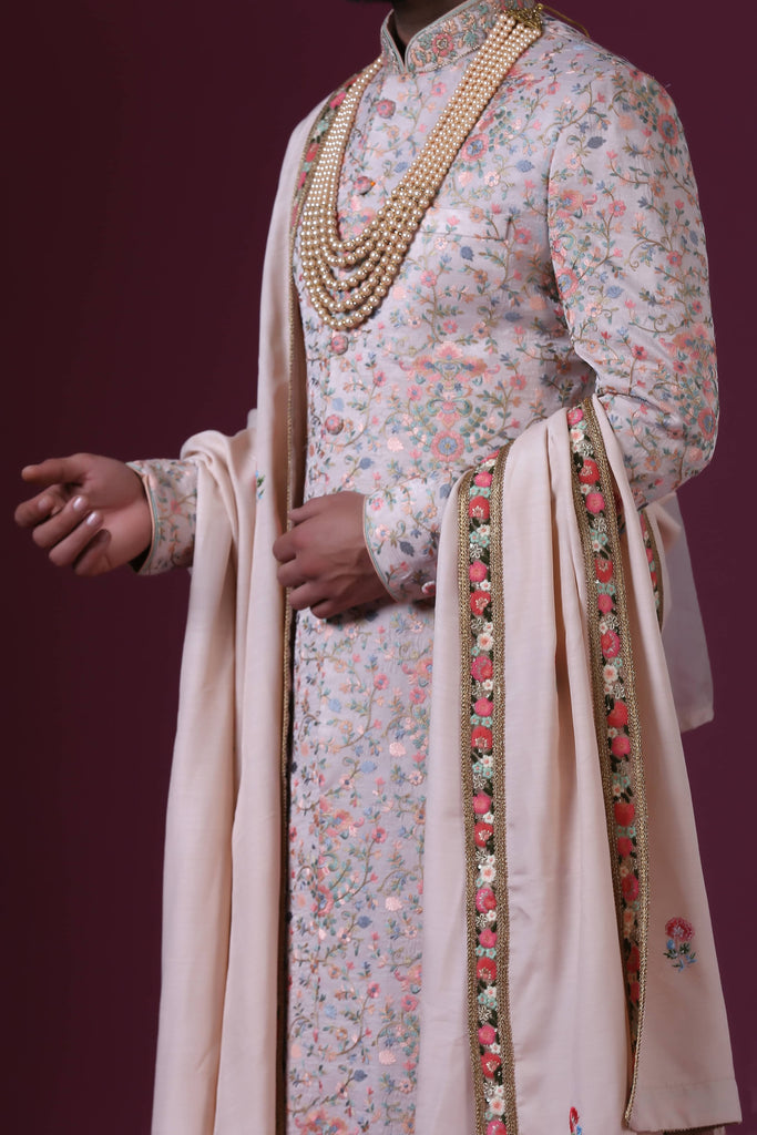 Charm in white with multicolor floral embroidery, exuding soft pastel elegance in this exquisite sherwani.