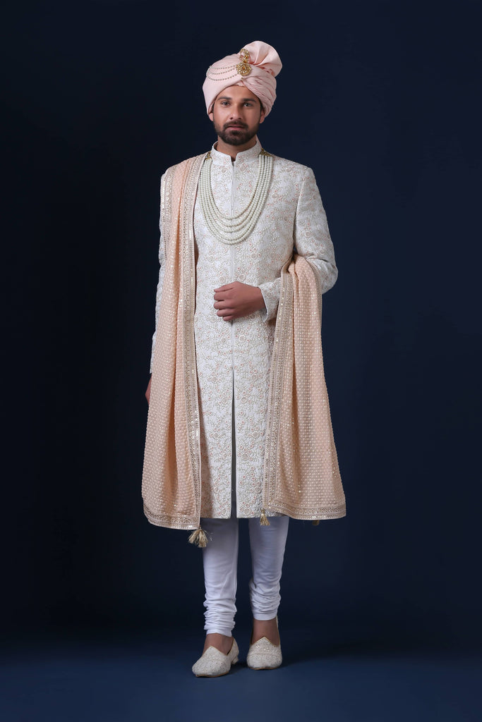 Elegantly adorned with delicate floral embroidery, this white Sherwani exudes timeless sophistication.