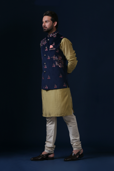 Elevate your style with our Navy Blue velvet Nehru jacket, adorned with contrasting floral embroidery. Paired perfectly with an olive kurta and off-white churidar trousers.